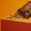 A bag of Nature's Path Love Crunch granola is tipped over, spilling its contents on a table top.